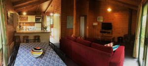 a living room with a table and red couches at Sandpiper Ocean Cottages in Bicheno