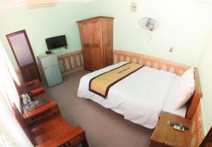 a bedroom with a bed and a television in it at Hoa Binh Hotel in Dong Hoi