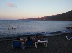a group of people sitting on chairs on a beach at Pomos Harbourbiew Villa in Pomos