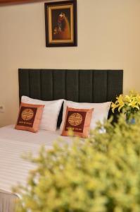 ein Schlafzimmer mit einem Bett mit zwei Kissen darauf in der Unterkunft Gia Loc Hotel in Hanoi