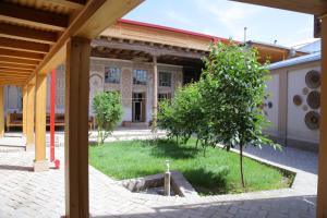 a courtyard with a tree in front of a building at Rabat Boutique Hotel in Samarkand