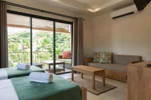 un salon avec deux lits et un canapé dans l'établissement Le Repaire - Boutique Hotel & Restaurant, à La Digue