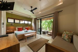 une chambre avec un lit et un canapé dans une pièce dans l'établissement Le Repaire - Boutique Hotel & Restaurant, à La Digue 37 autres photos