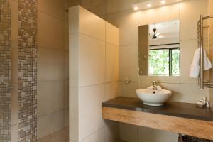 une salle de bain avec un lavabo et un miroir dans l'établissement Le Repaire - Boutique Hotel & Restaurant, à La Digue