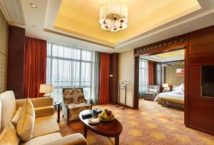 sala de estar con sofá y habitación con cama en Leeden Jingxi Hotel, en Guangzhou