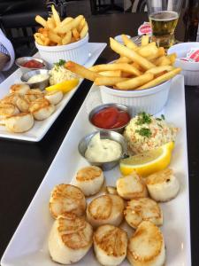 a table with two plates of food and french fries at Harbour Guesthouse in Clark's Harbour