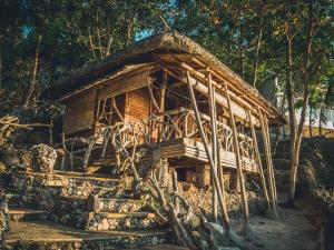 a wooden house with a pile of logs in front of it at Nature's Eye Resort in Guimaras
