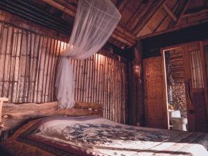 a bedroom with a bed in a wooden room at Nature's Eye Resort in Guimaras