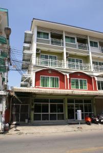 un edificio rojo y blanco al lado de una calle en Poi De Ping, en Chiang Mai