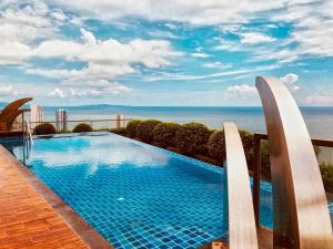 a swimming pool with a view of the ocean at The Peak Towers Pattaya in Pattaya South