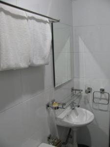 a white bathroom with a sink and a mirror at Fargo Boutique Hotel in Kuantan