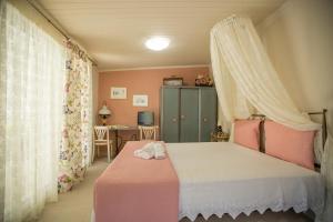 a bedroom with a bed with a canopy at Ancient Corinth Guest House in Korinthos
