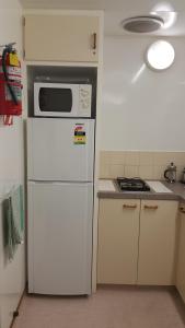 een keuken met een magnetron en een koelkast bij Wilderness Motel Accommodation in Haast