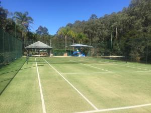 a tennis court with a net and a gazebo at Blackwattle at Barrington Tops in Bandon Grove