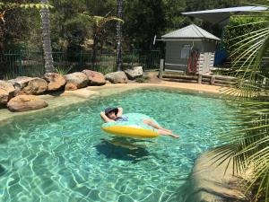 a man in a pool in a raft in the water at Blackwattle at Barrington Tops in Bandon Grove