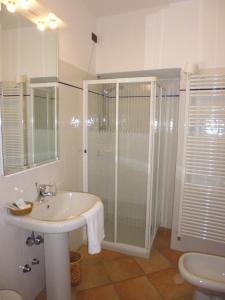 baño blanco con ducha y lavamanos en B&B Il Nido en Raffa