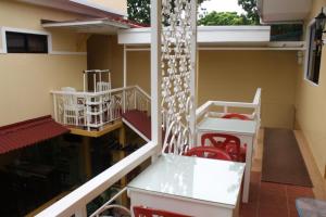 a room with a table and red chairs and a balcony at Oslob Malonzo Pension House in Oslob