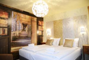 パリにあるオテル マラーのベッドルーム1室(白いベッド2台、シャンデリア付)