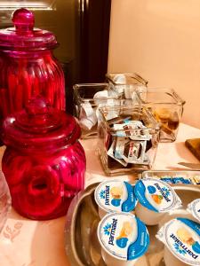 un jarrón rojo sentado sobre una mesa con platos en Palazzo Sciacca, en Patti