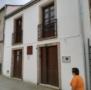 
a person standing in front of a building at Albergue O Candil in Melide
