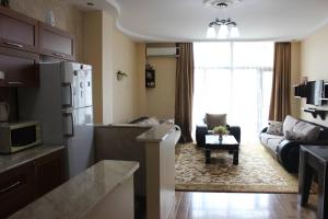 a kitchen and living room with a couch and a table at Mari's Apartment Kazbegi in Batumi