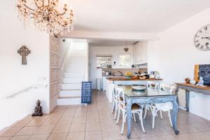 cocina con mesa, sillas y reloj en Villa Orquidea - Can Juan Calero, en Santa Eulària des Riu
