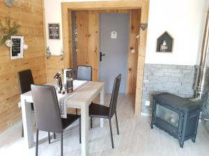 a dining room with a table and chairs and a wood stove at La petite chaumiere in Saint-Maurice-sur-Moselle