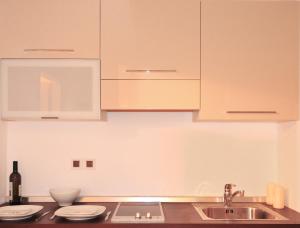 a kitchen with white cabinets and a sink at Gerakari Suites in Agia Pelagia