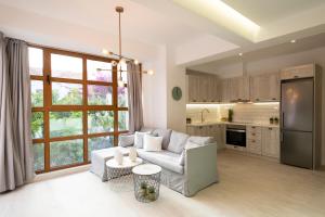 a living room with a white couch and a kitchen at Feels like Home in Rethymno