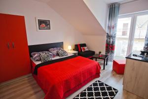 a bedroom with a red bed and a chair at Błękit Oceanu in Władysławowo