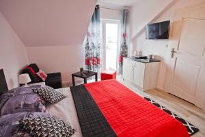 a bedroom with a large bed with a red blanket at Błękit Oceanu in Władysławowo