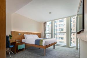 pokój hotelowy z łóżkiem i dużym oknem w obiekcie Summit View Kowloon w Hongkongu