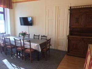 ein Esszimmer mit einem Tisch, Stühlen und einem TV in der Unterkunft Ferienwohnung Alt Görlitz in Görlitz