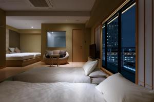 a hotel room with two beds and a large window at Osaka View Hotel Honmachi in Osaka
