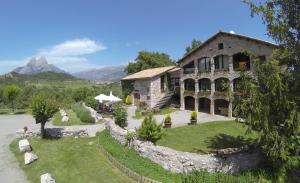 un gran edificio de piedra con un jardín delante de él en Camping Susen, en Saldes