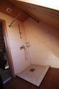 a bathroom with a shower with a tile floor at Ranna puhkemaja in Lemsi