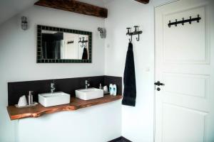 
a bathroom with two sinks and a mirror at Andelen Guesthouse in Ærøskøbing
