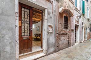 un vecchio edificio con una porta in legno su una strada di SAINT MARK'S BASILICA @200 meters a Venezia