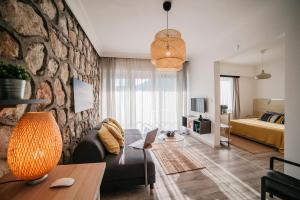 a living room with a couch and a stone wall at True Blue Boutique Hotel Kalkan in Kalkan