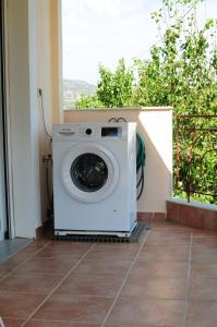 リメナリアにあるMantos Apartmentの窓のあるポーチに洗濯機が備わります。