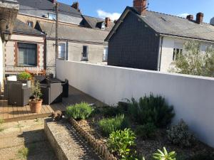 un patio trasero de una casa con una valla blanca en La Demeure d'Alexandra en Cholet