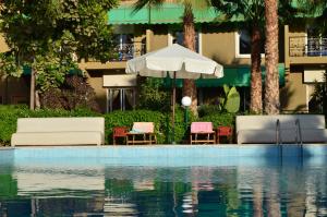 塔鲁丹特Almounia Hotel & Spa的建筑物旁边有带椅子和遮阳伞的游泳池