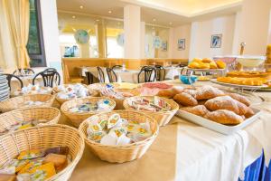 einen Tisch mit Körben mit Brot und Gebäck darauf in der Unterkunft Hotel Golf in Cattolica