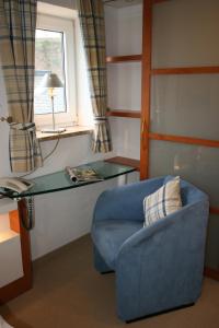 a living room with a blue couch and a glass table at Hanseat in Helgoland