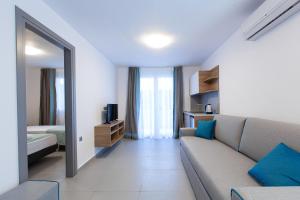 a living room with a couch and a mirror at Saint Lucas Suites in Nea Potidaea