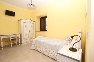 1 dormitorio con 1 cama, vestidor y escritorio en Azienda Agrituristica La Tenuta del Falco, en Piedimonte San Germano