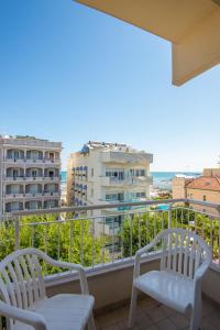 een balkon met 2 stoelen en uitzicht op de oceaan bij Hotel Golf in Cattolica