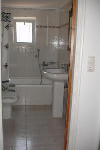 łazienka z umywalką, wanną i toaletą w obiekcie Mathia Apartments w mieście Mathía