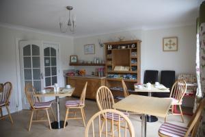 a dining room with two tables and chairs at Bridgeburnhouse Bed and Breakfast in Treantagh