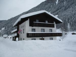 a building covered in snow in front of a mountain at Adlerhorst in Sellrain